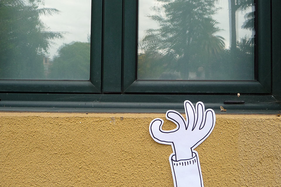 La mano, no más, junto a una ventana